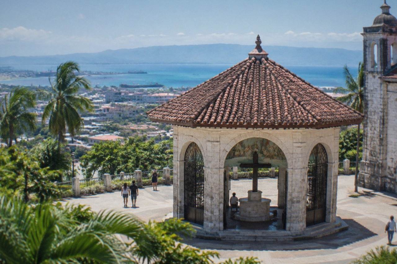 View over Cebu City rooftops toward the sea with green hills in the distance