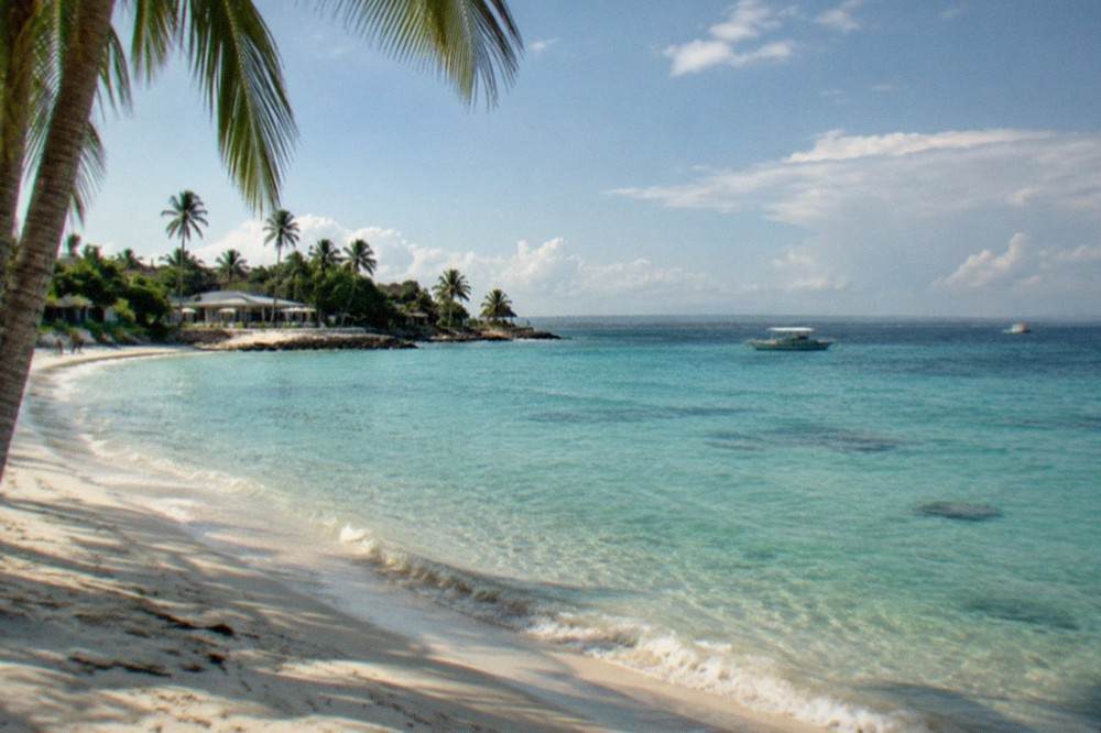 Palm-fringed beach and calm turquoise water on Mactan Island