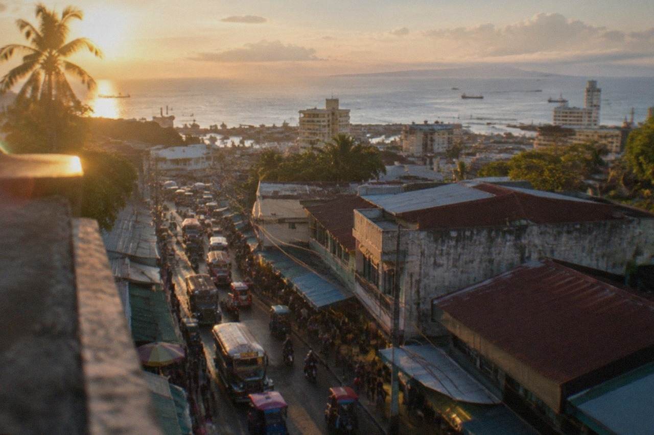 Evening city lights and illuminated buildings seen from a rooftop overlooking Cebu City