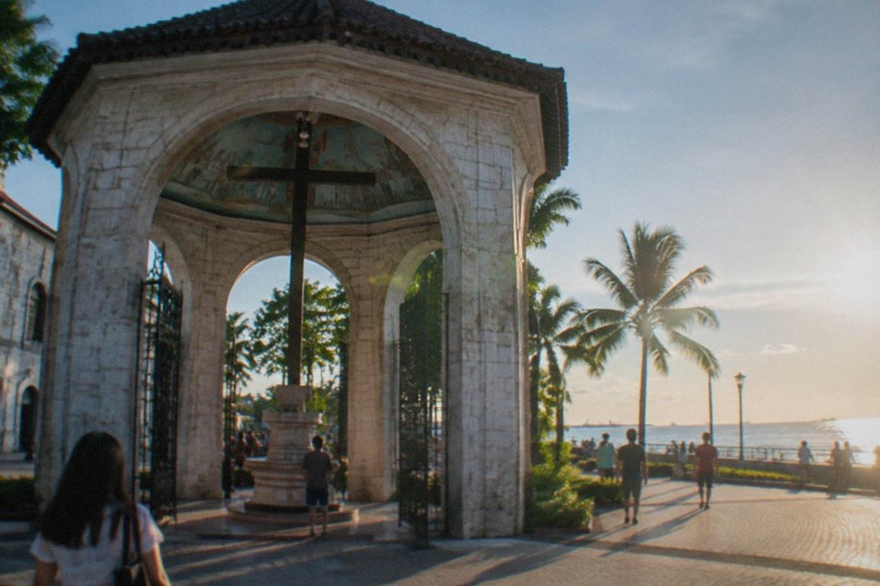 Visitors walking along a waterfront promenade in Cebu on a bright day