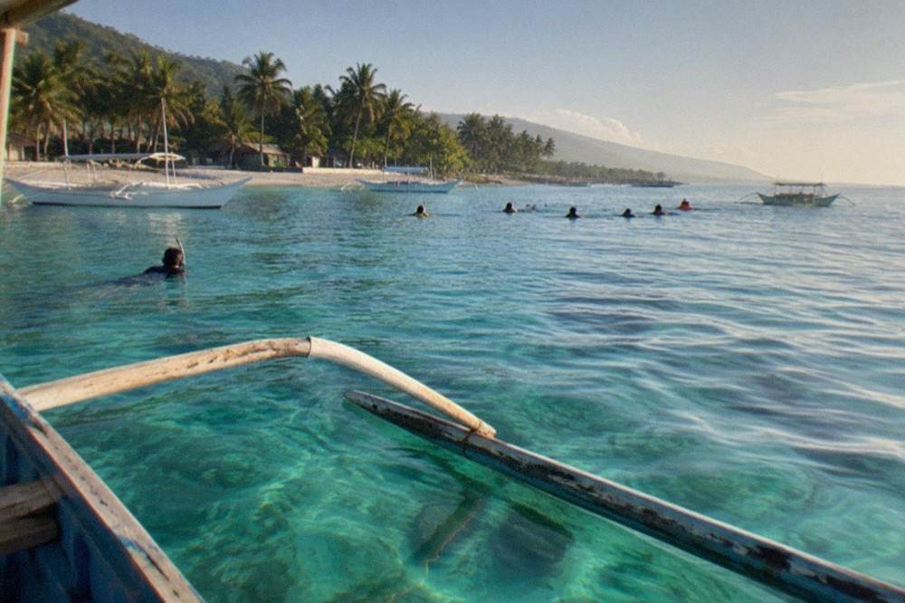 A wooden outrigger boat at the Oslob whale shark interaction area in the early morning