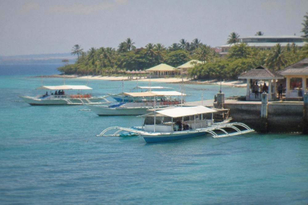 Outrigger boats moored at a Mactan jetty ready for island hopping