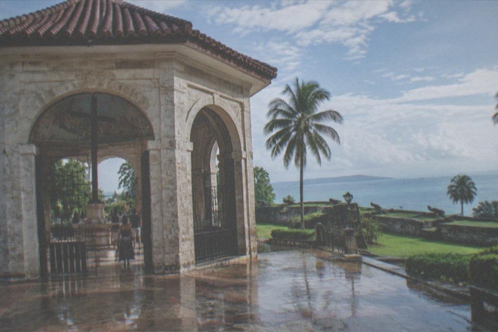 A stone fort's grassy ramparts under a tropical sky in Cebu City