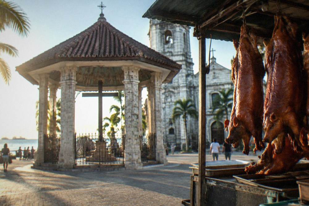 Whole roasted lechon pigs hanging in a Cebu City market stall