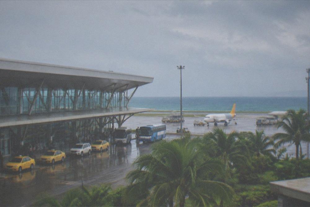 A modern airport terminal exterior on Mactan Island with taxis and buses at the arrivals curb