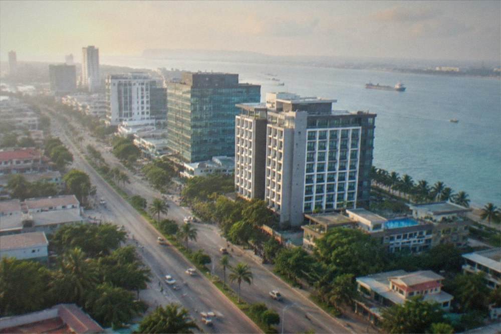 Modern hotel and office buildings along a wide Mandaue boulevard at dusk with light traffic