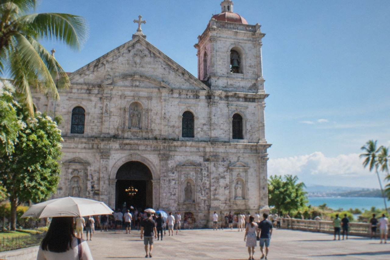The baroque stone facade of the Basilica del Santo Nino in Cebu City seen from the plaza on a bright morning