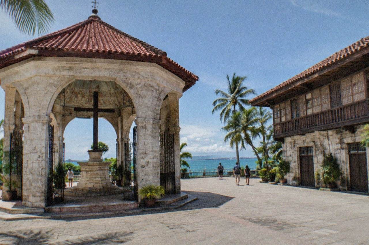 A restored Spanish-era stone and hardwood house with a tiled roof and wooden balconies in Cebu City