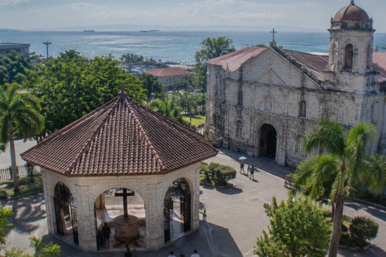 Facade of a stone cathedral in downtown Cebu City under a bright sky