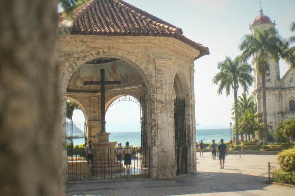 Plaza and palm trees in front of a heritage church in downtown Cebu City