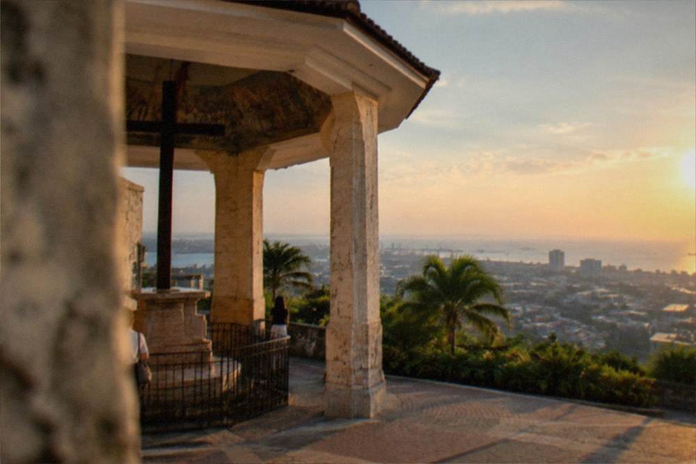 A panoramic view from a hilltop deck over the rooftops of Cebu City toward the sea