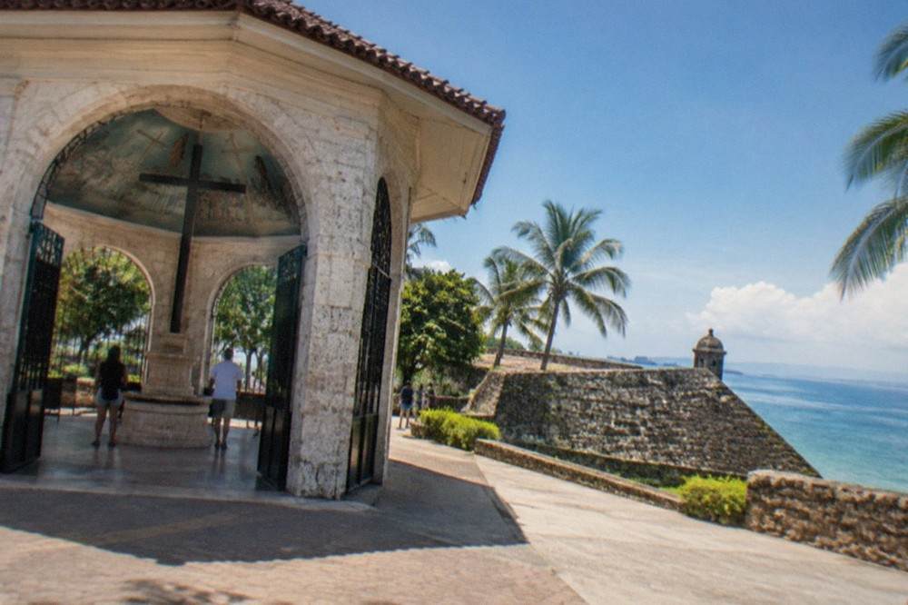 A triangular stone bastion with coral-block walls under a blue sky in Cebu City