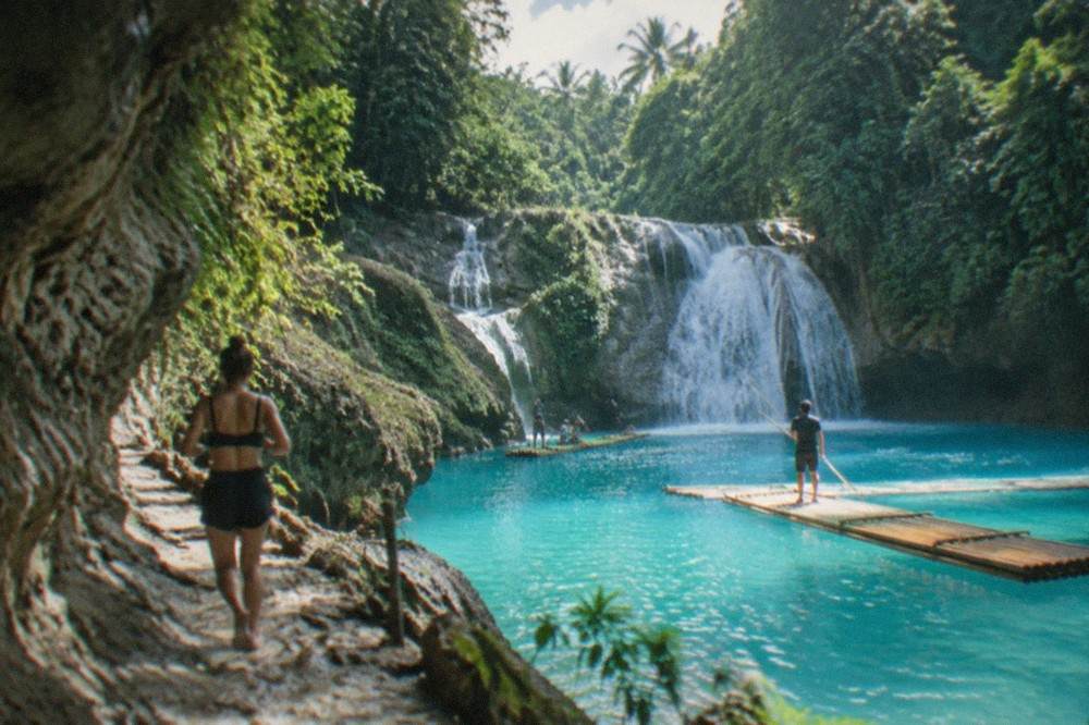 Bamboo rafts floating in the blue main pool at Kawasan Falls