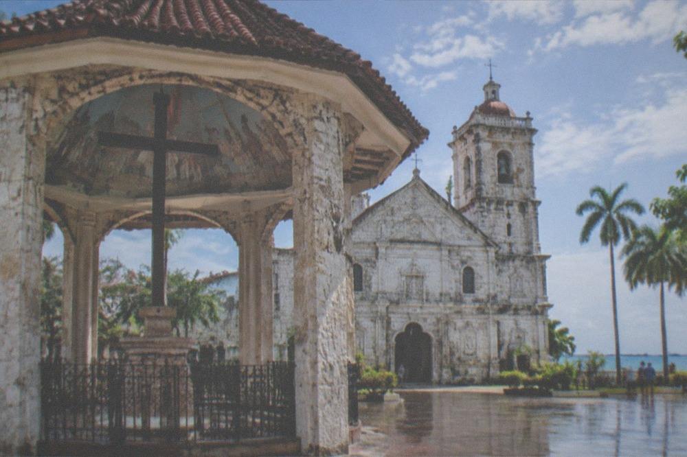 The facade and bell tower of the Basilica Minore del Santo Niño beside the Magellan's Cross pavilion in Cebu City