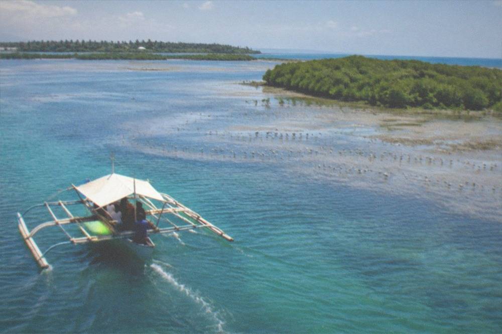 A small outrigger bangka ferry crossing the channel between Mactan and Olango Island, Cebu, Philippines