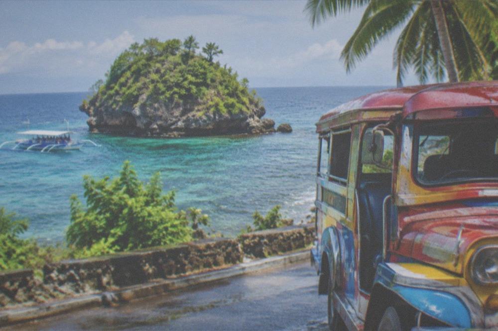 A colorful jeepney parked on a busy street in a Philippine town