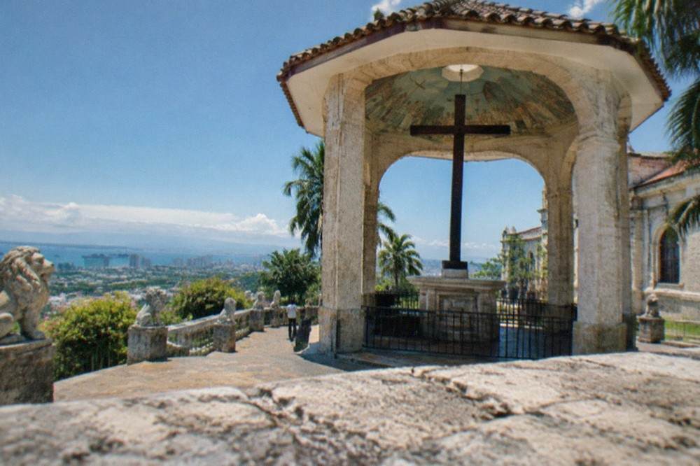 Stone lion statues lining a terrace walkway with a view of Cebu City below