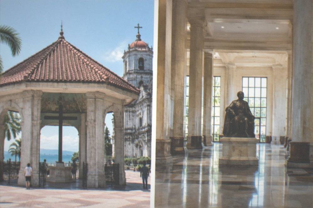 A polished interior hall with tall columns, marble floors and a seated bronze statue at its centre