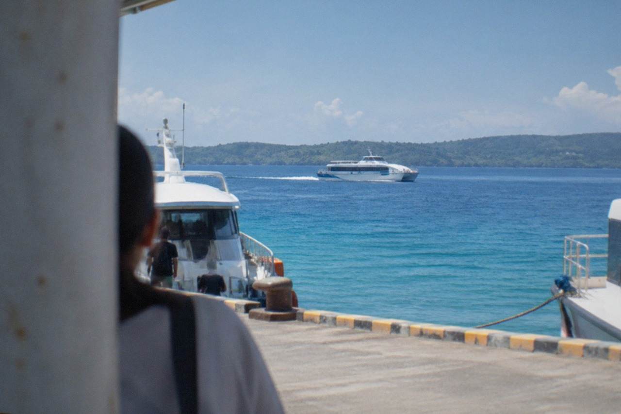 A fastcraft ferry crossing calm blue water between Cebu and Bohol with green islands on the horizon
