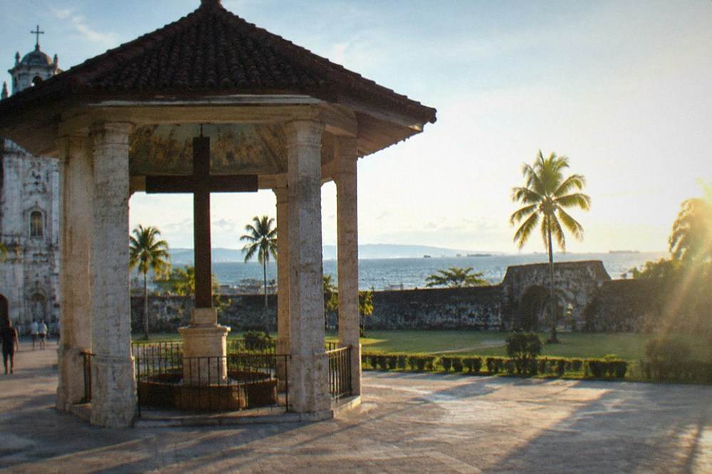 A colonial-era stone fort with thick walls and a grassy courtyard under a bright sky