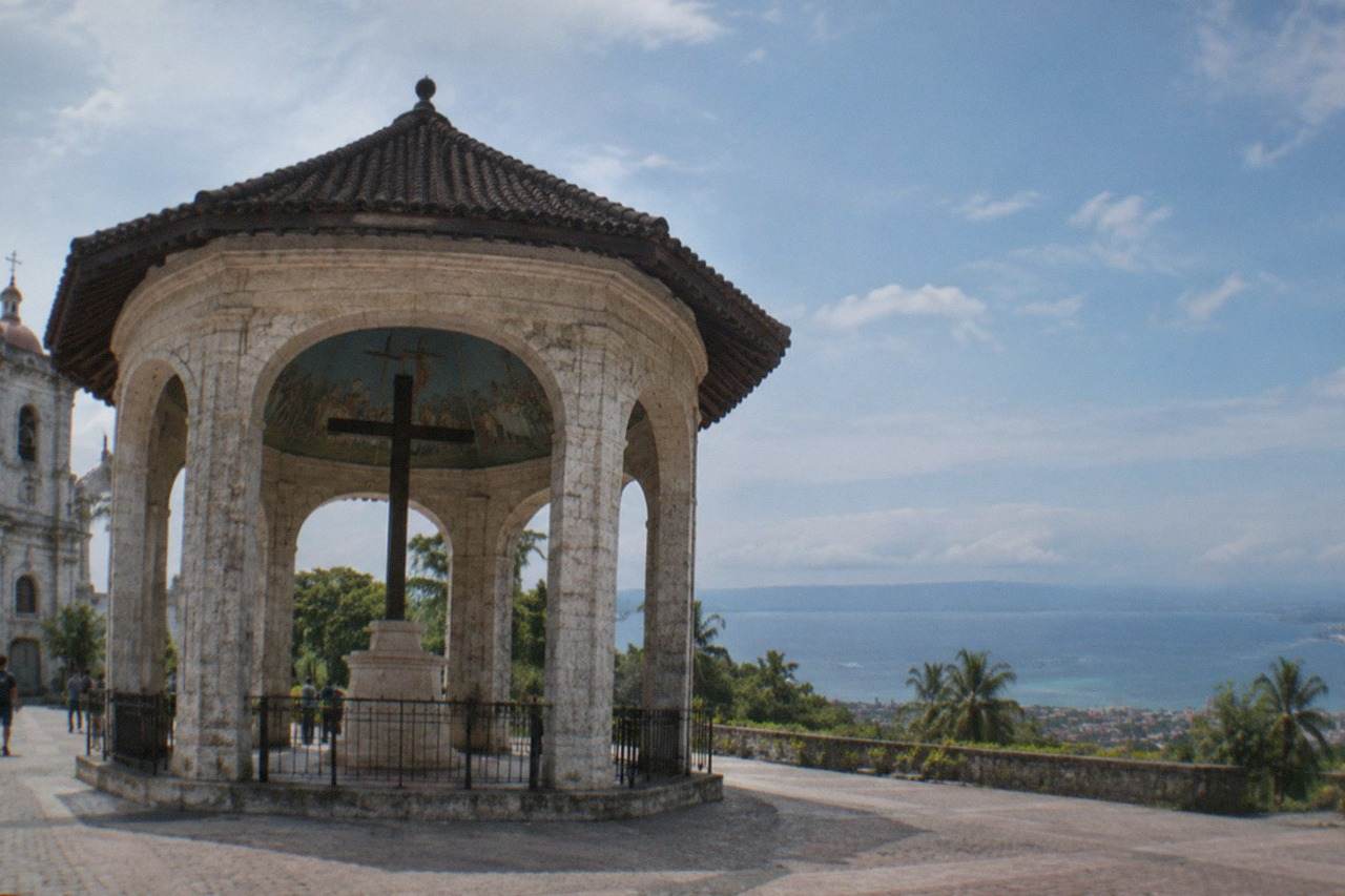 A sunny view over Cebu's coastline with blue water and green hills