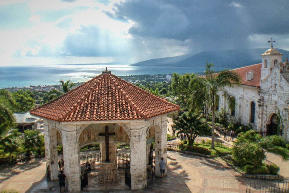 A rainstorm passing over Cebu's hills with dark clouds and shafts of sunlight