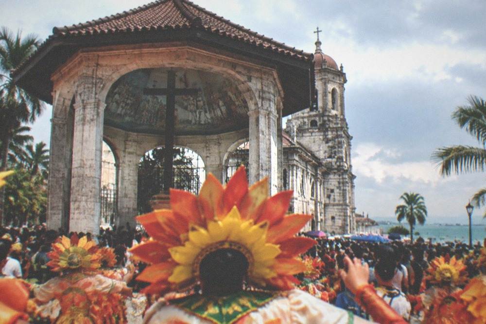 Dancers in bright Sinulog costumes performing in a crowded Cebu City street