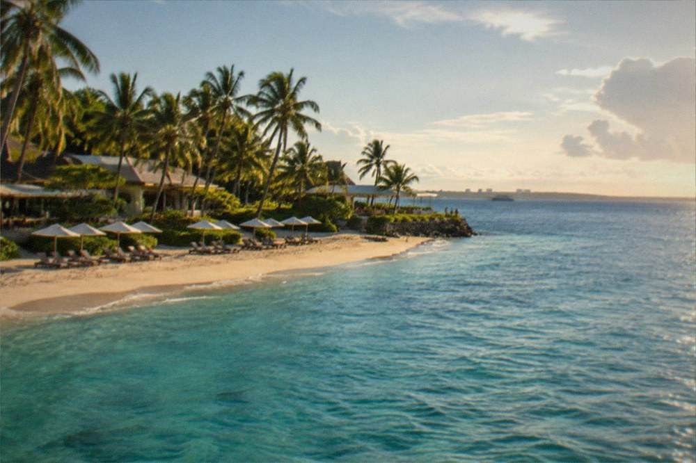 A beachfront resort with sun loungers facing calm evening water on Mactan Island, Cebu