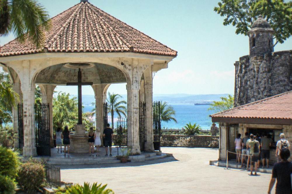 Visitors paying entrance fees at a ticket booth beside a Spanish-era stone fort in Cebu