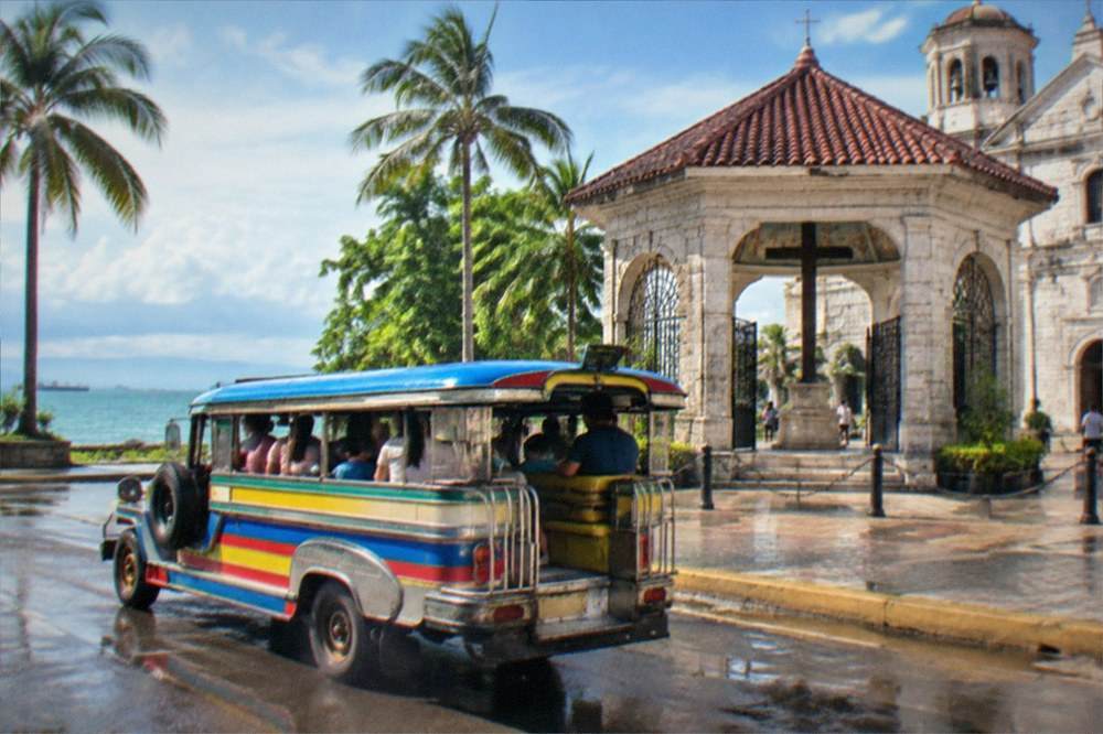 Parents and children riding a colourful jeepney through a city street