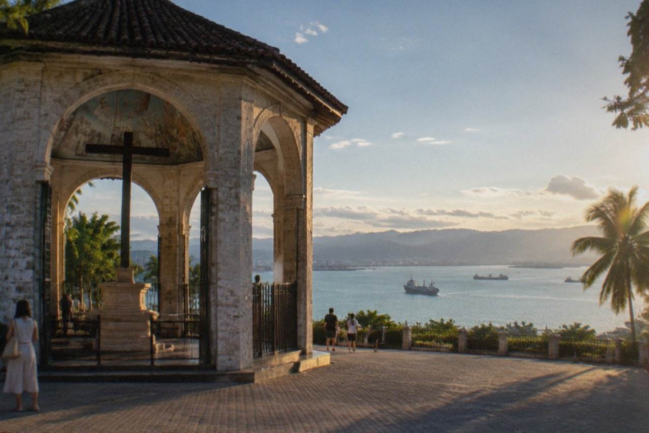 A wide view of Cebu City's waterfront with ships in the channel and hills behind
