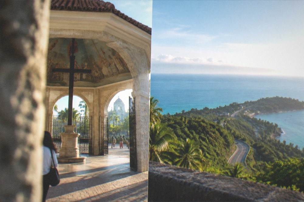 A viewpoint above green hills and a winding coastal road on a clear morning in the Philippines
