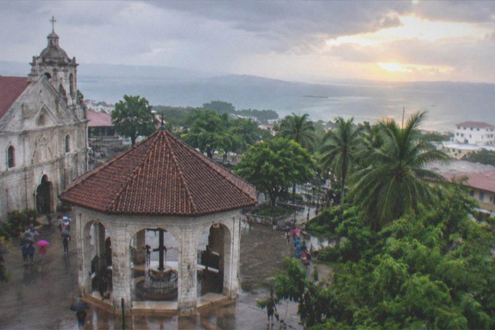 Sunset breaking through parting storm clouds over the Cebu highlands and coastline