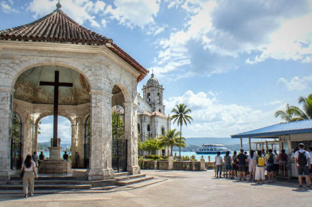 A ferry ticket counter window with a queue of travellers at Cebu City pier