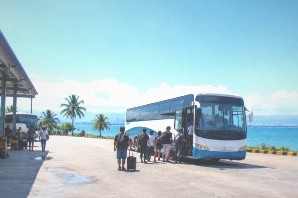 A long-distance bus loading passengers at the Cebu South Bus Terminal in the early morning