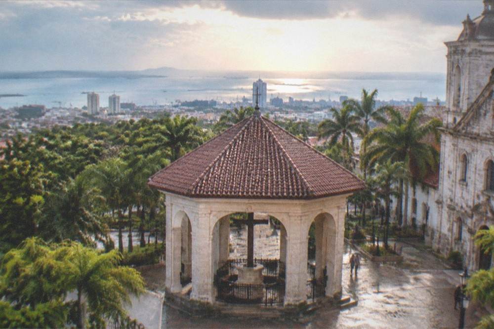 Downtown Cebu City skyline under a mix of sun and clouds above the heritage district