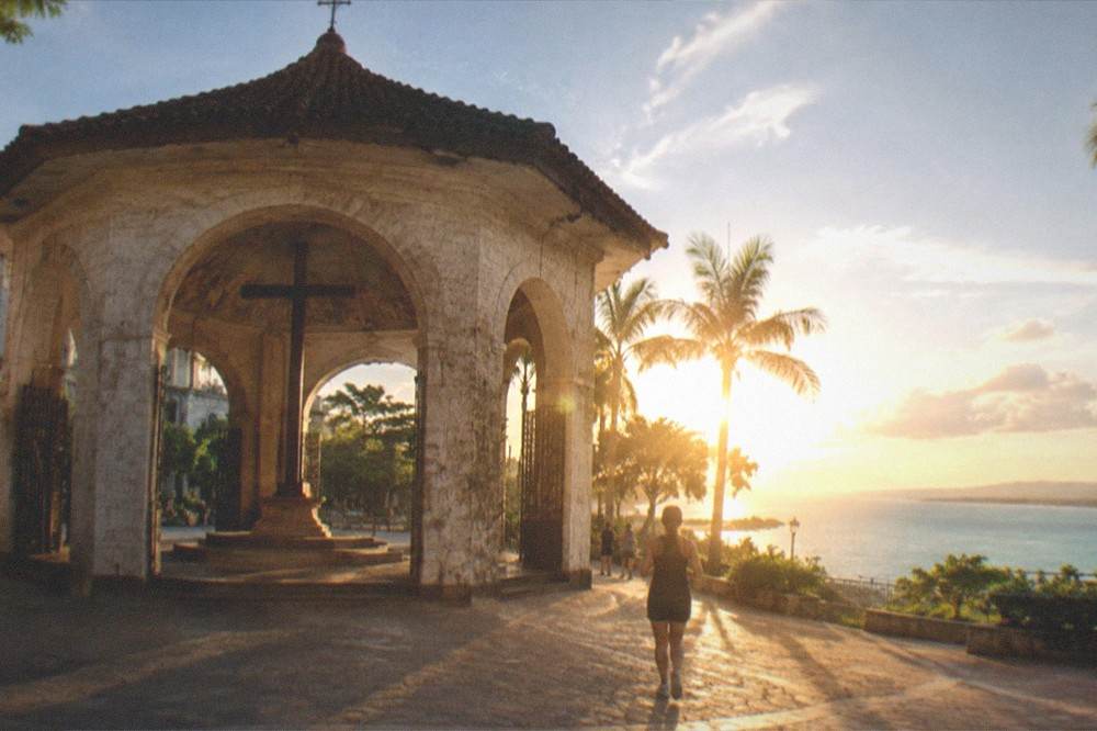 A wide view of turquoise sea and green coastline in south Cebu at golden hour