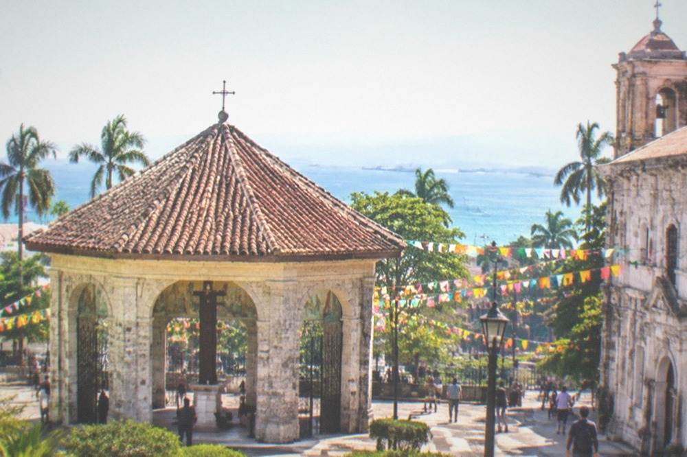 A street in Cebu City decorated with colorful banners and crowded with festival visitors in the afternoon