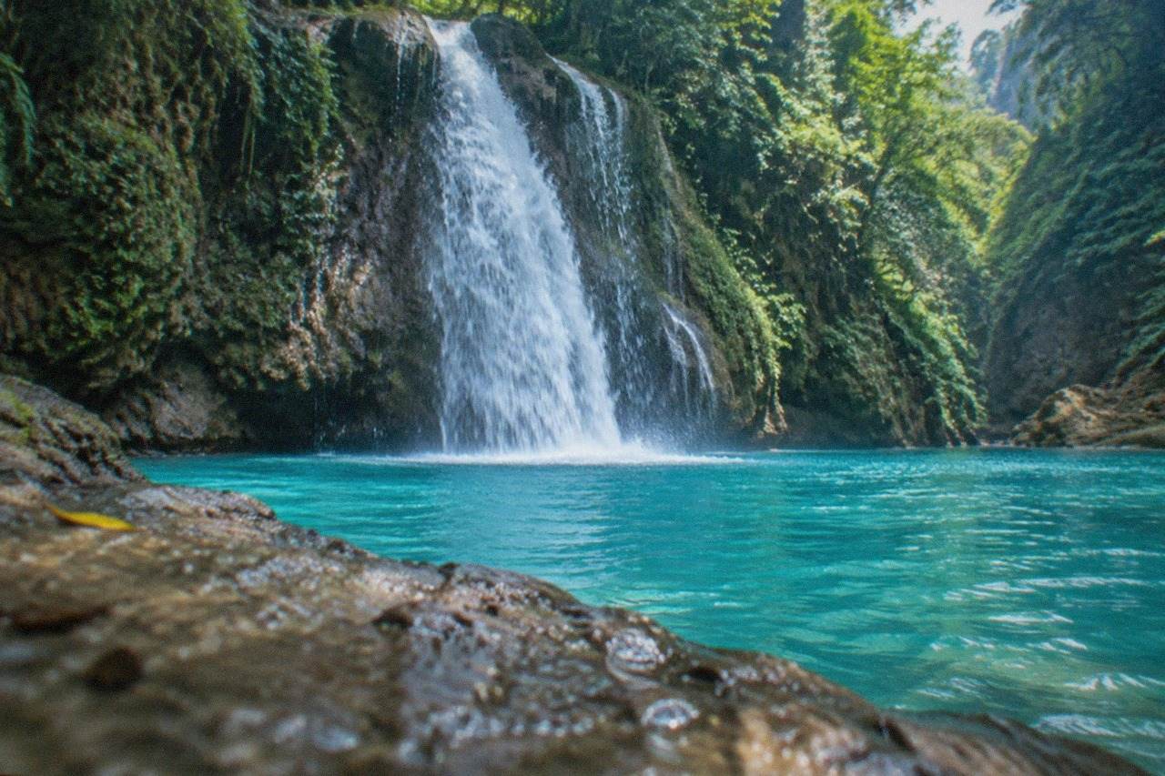Kawasan Falls plunging into a turquoise pool surrounded by jungle in Cebu, Philippines
