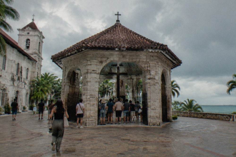 Magellan's Cross pavilion in Cebu City with visitors gathered around the painted ceiling